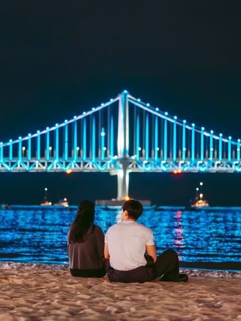 광안대교 앞에 앉은 두 사람